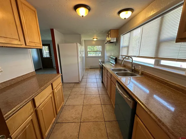 a kitchen with stainless steel appliances granite countertop a sink a stove and a refrigerator