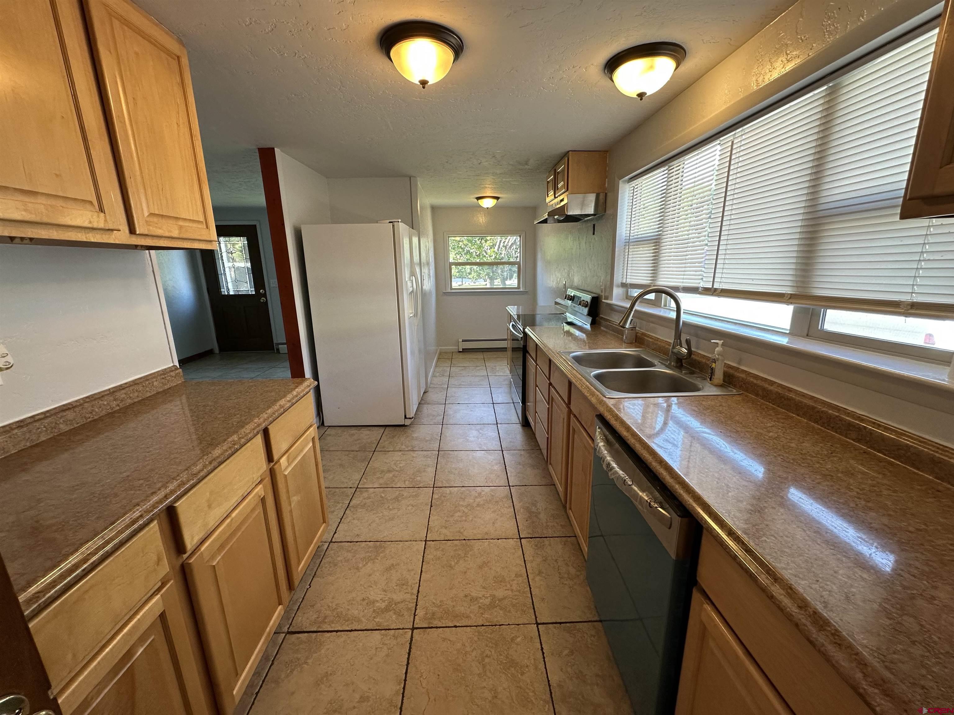 490 West Main Street Cedaredge, CO 81413 - Photo 22 of 31 a kitchen with stainless steel appliances granite countertop a sink a stove and a refrigerator