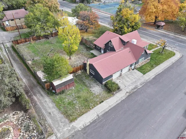 an aerial view of a house with garden space and street view