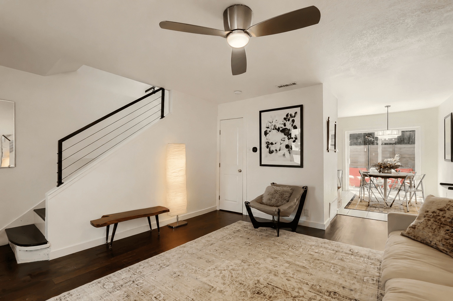 6211 Manor Road, Unit 105 Austin, TX 78723 - Photo 4 of 18 Hardwood floors stretch across the living space, leading to a dining area with a modern aesthetic and outdoor access.