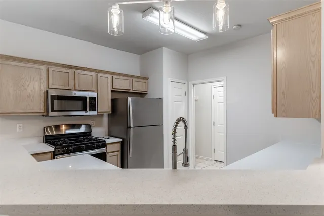 a kitchen with stainless steel appliances a refrigerator and a stove top oven