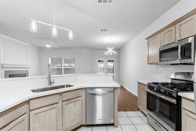 a kitchen with stainless steel appliances granite countertop a sink stove and microwave