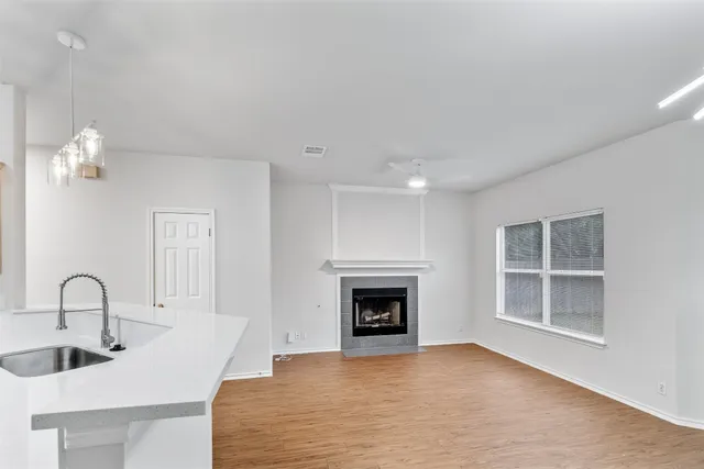 a view of an empty room with a fireplace and window