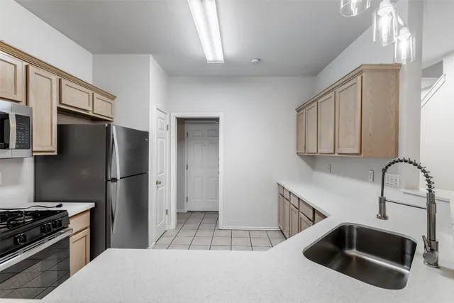 a kitchen with granite countertop a refrigerator stove and sink