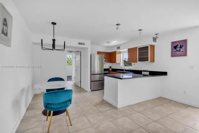 a kitchen with stainless steel appliances granite countertop a sink and a refrigerator