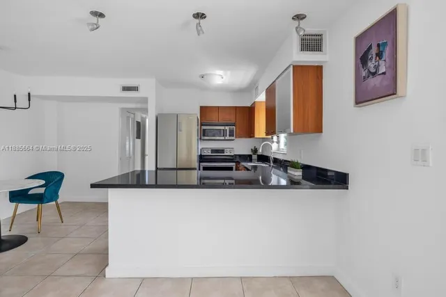 a kitchen with stainless steel appliances granite countertop a sink and a stove top oven