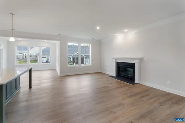 an empty room with wooden floor and fireplace