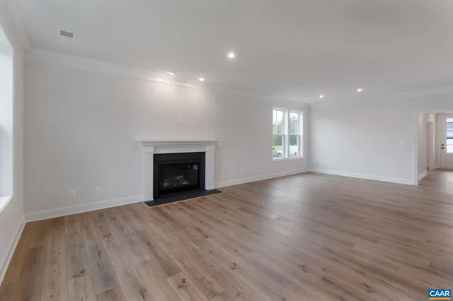 an empty room with wooden floor and fireplace