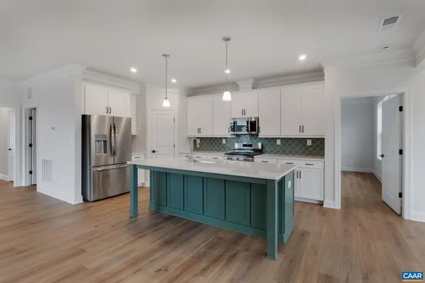 a kitchen with a sink stainless steel appliances and wooden floor