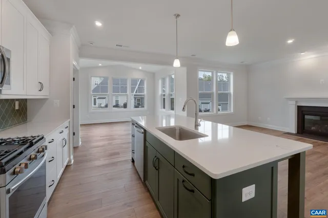 a large kitchen with stainless steel appliances a large center island and a wooden cabinets