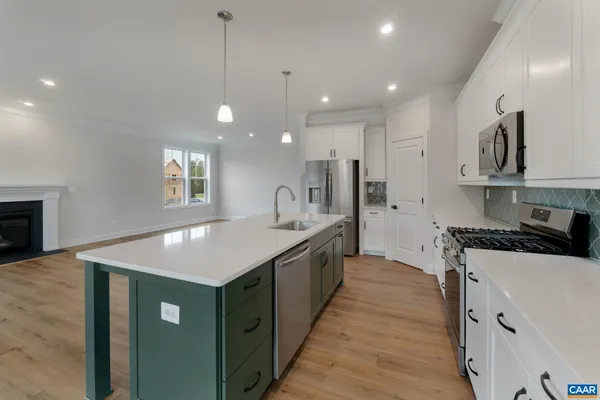 a large kitchen with stainless steel appliances granite countertop a sink a stove and a refrigerator