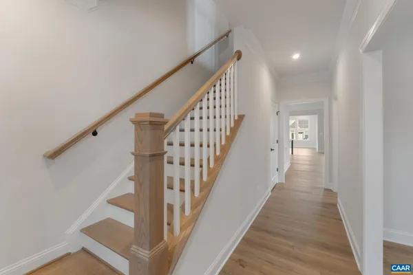 a view of staircase with wooden floor and white walls