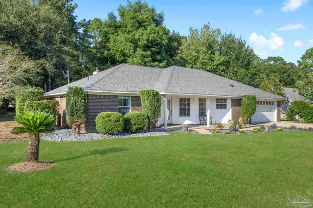 a view of a house with a yard and sitting area