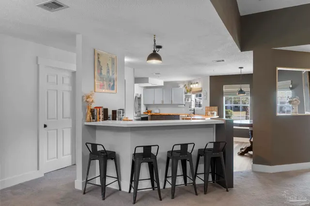 a kitchen with kitchen island a dining table and chairs