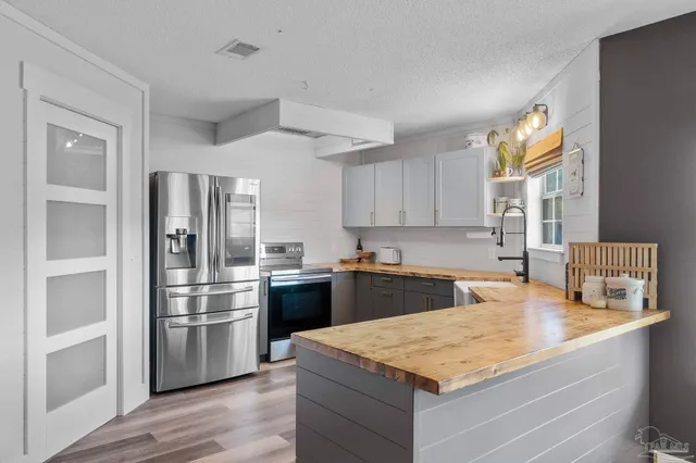 a kitchen with stainless steel appliances granite countertop a stove and a refrigerator