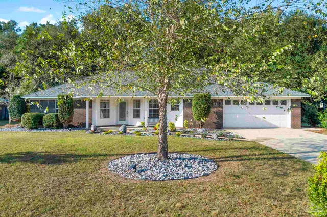 a front view of a house with a garden and yard