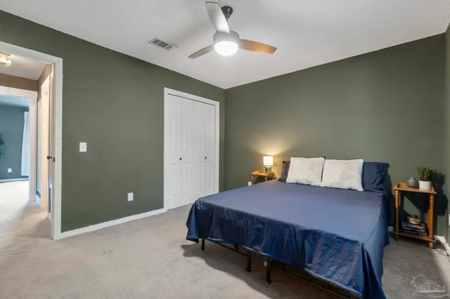 a bed sitting in a spacious bedroom next to a window