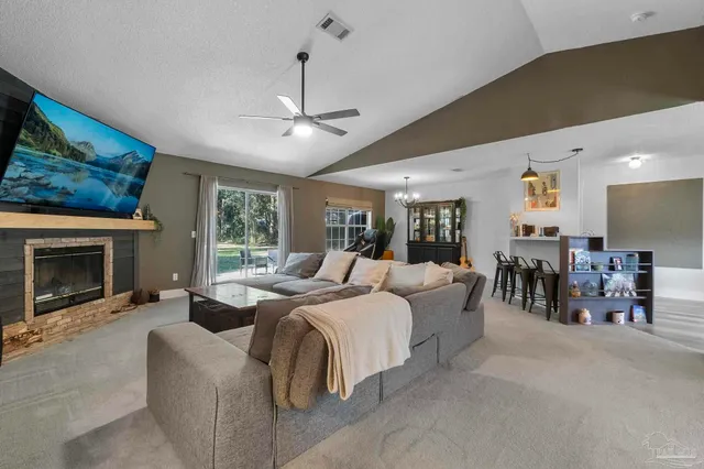 a living room with furniture a chandelier and a large window