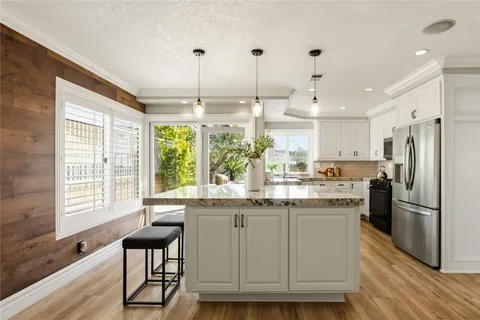 a kitchen with kitchen island white cabinets and stainless steel appliances