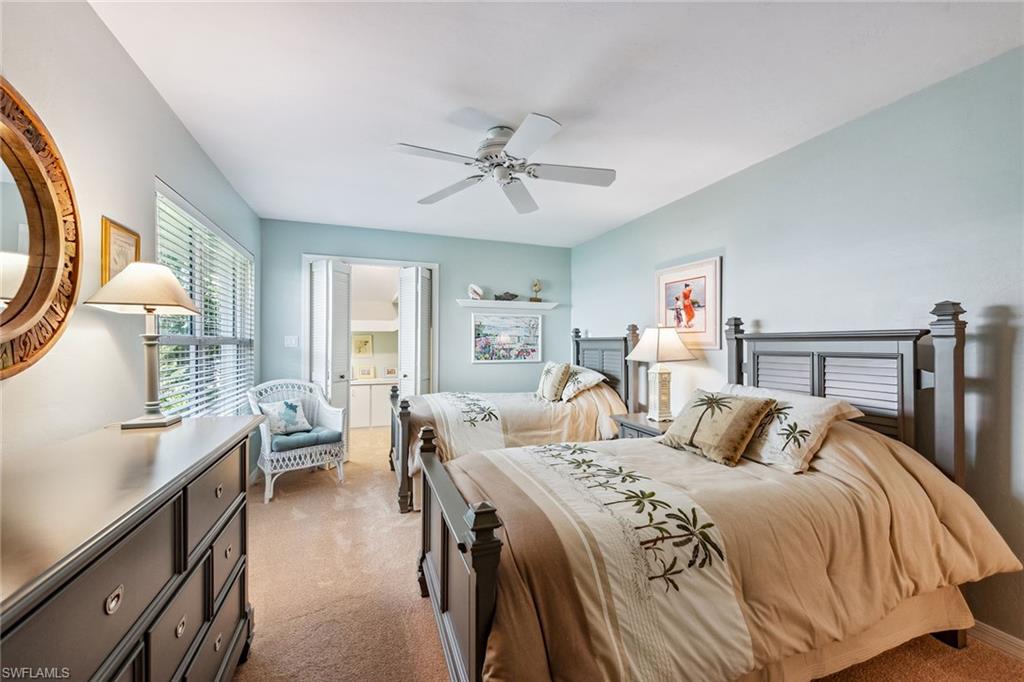 116 Napa Ridge Way Naples, FL 34119 - Photo 15 of 28 a bedroom with a balcony a bed and a chandelier