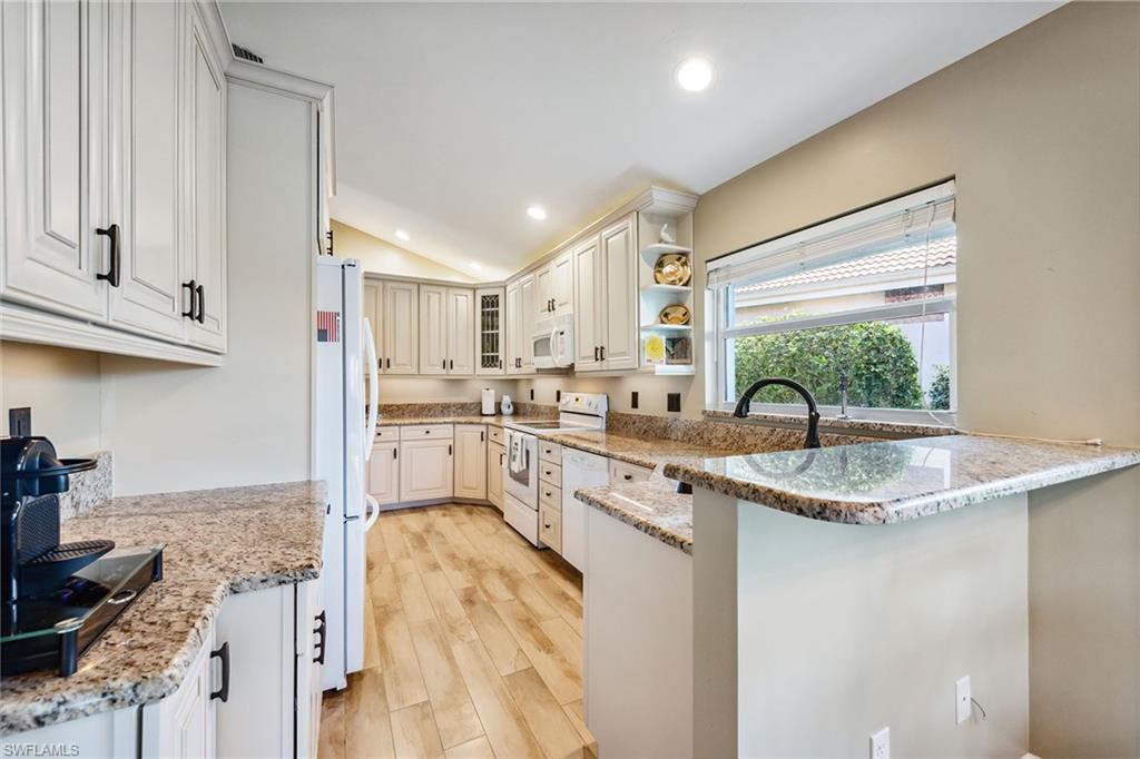 116 Napa Ridge Way Naples, FL 34119 - Photo 5 of 28 a kitchen with stainless steel appliances granite countertop a sink stove and cabinets