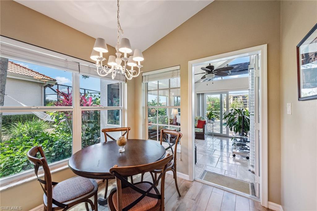 116 Napa Ridge Way Naples, FL 34119 - Photo 8 of 28 a view of a dining room with furniture a chandelier and wooden floor