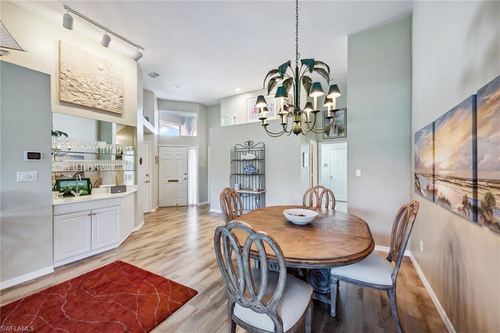 116 Napa Ridge Way Naples, FL 34119 - Photo 9 of 28 a view of a dining room with furniture and chandelier