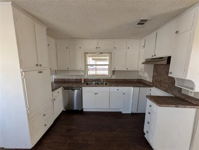 a kitchen with granite countertop white cabinets and white appliances