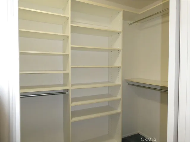 a view of walk in closet with empty racks
