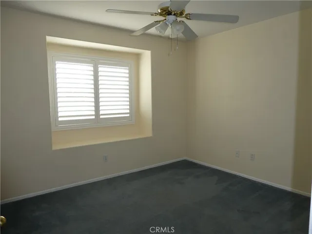an empty room with a window and a fan