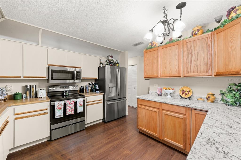 443 Foxdale Road Lake Placid, FL 33852 - Photo 11 of 31 a kitchen with stainless steel appliances granite countertop a refrigerator a stove top oven a sink and dishwasher with wooden floor