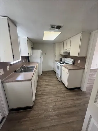 a kitchen with kitchen island a stove a sink and a refrigerator
