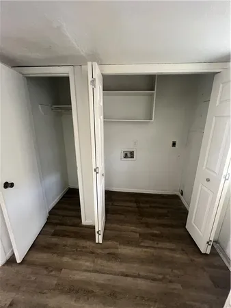 an empty room with wooden floor and entrance