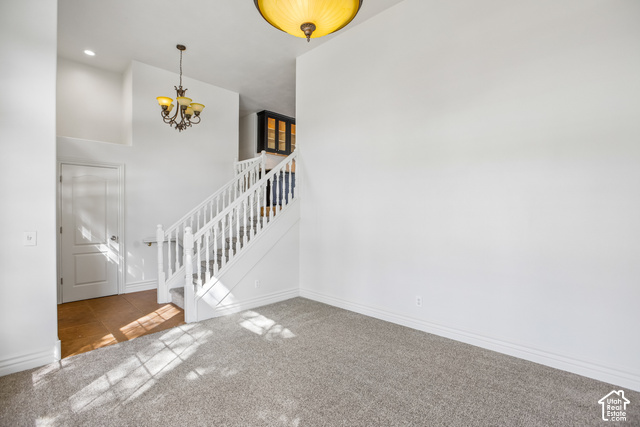 190 North 100 West Alpine, UT 84004 - Photo 3 of 31 Carpeted flooring, high ceilings, traditional chandelier, white staircase with balusters, and wood-finish flooring