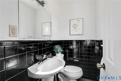 a bathroom with a toilet a sink and mirror