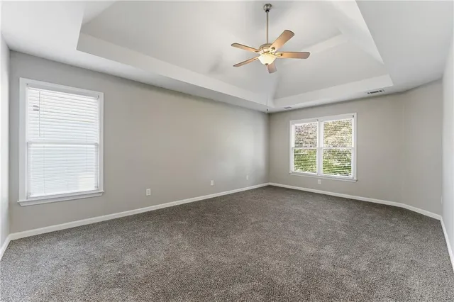 an empty room with fan and windows