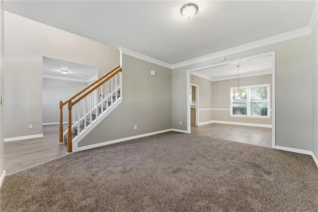 a view of an empty room with stairs and a window