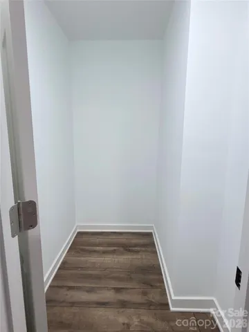 a view of a room with wooden floor and white walls