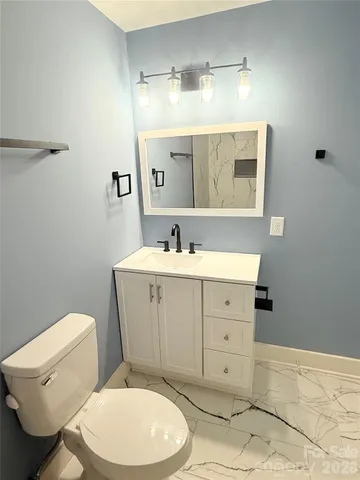 a bathroom with a toilet a sink a mirror and vanity