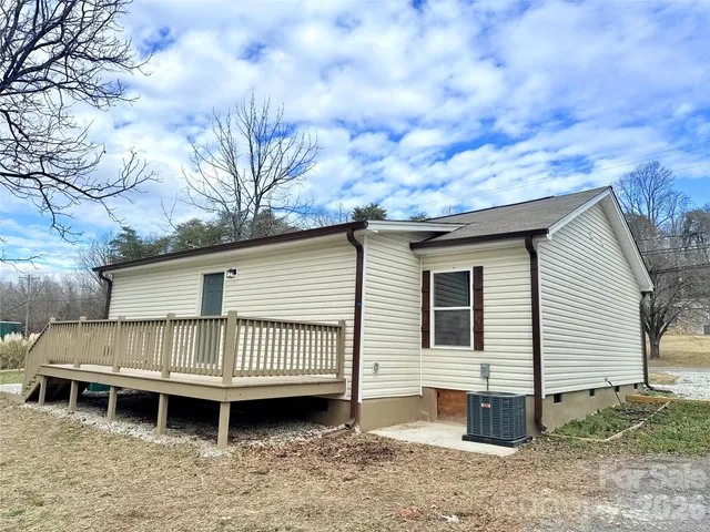 a view of a house with a yard and wooden deck