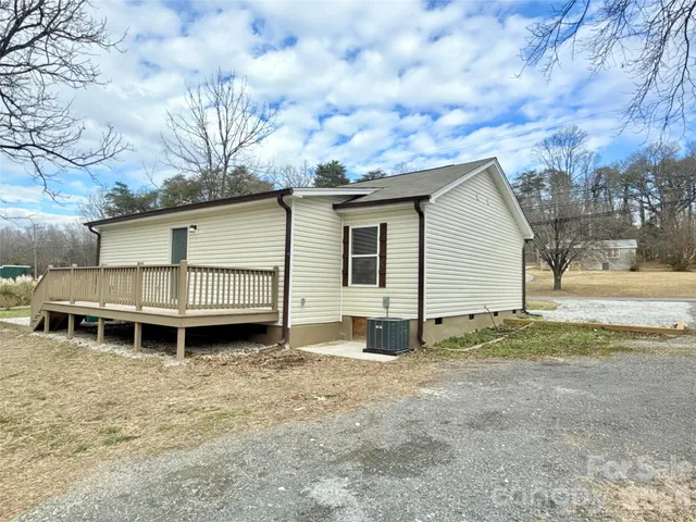 a view of a house with a yard and wooden fence