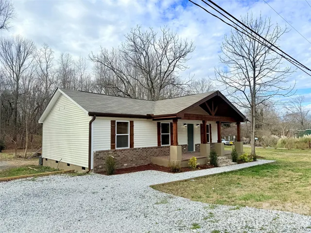 a front view of house with yard and trees around