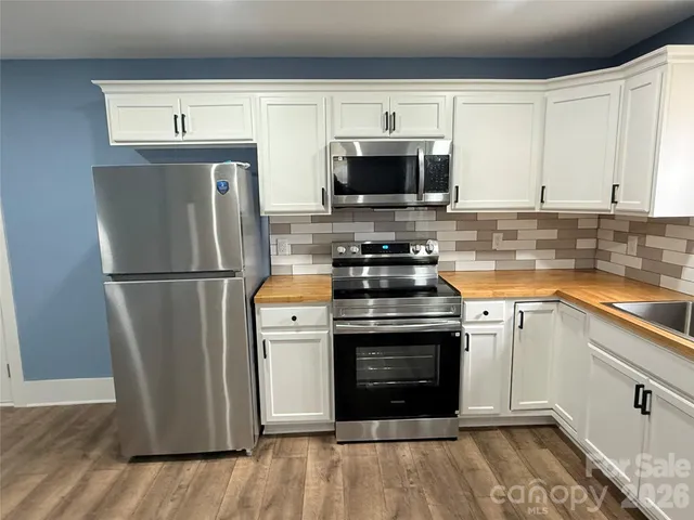 a kitchen with stainless steel appliances a stove microwave and refrigerator
