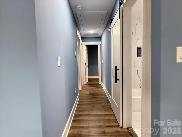 a view of a hallway with wooden floor and staircase