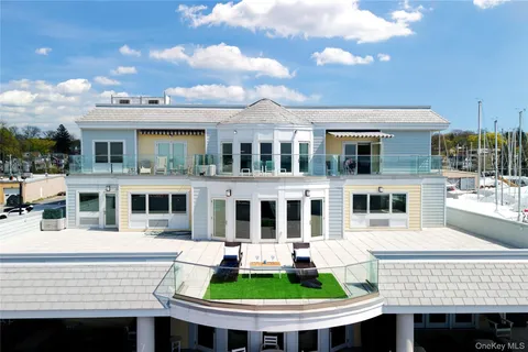 a front view of residential houses with yard and ocean view