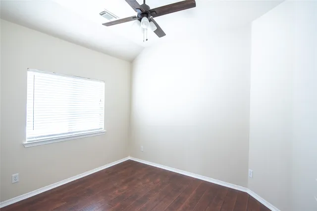 an empty room with a window and a fan
