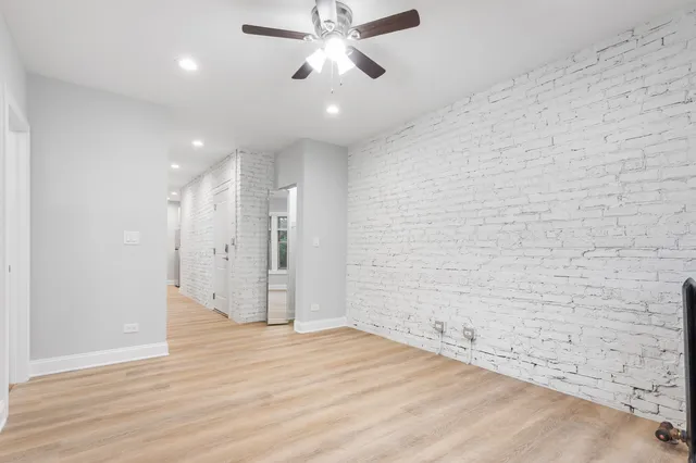 a view of a livingroom with a ceiling fan window and wooden floor