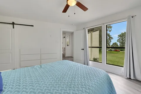 a bedroom with a bed and a large window