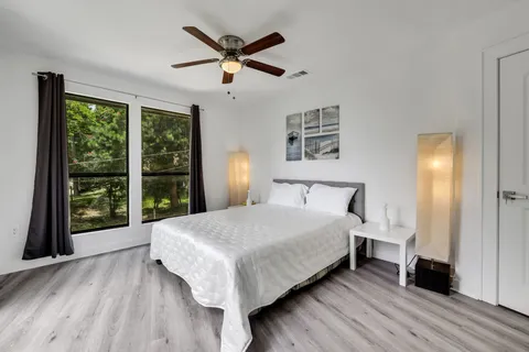 a large bedroom with a bed and a large window