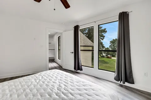 a view of a livingroom with wooden floor and a bed